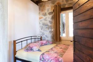Ce lit se trouve dans un dortoir doté d'un mur en pierre. dans l'établissement Split rustic house on the hill for 10 people, à Podstrana