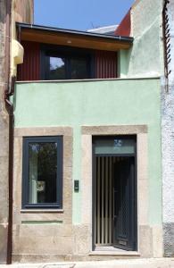 un edificio con dos ventanas y una puerta en Bonjóia Porto Guest House, en Oporto