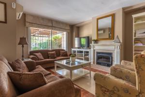 uma sala de estar com sofás e uma lareira em Chalet Cortijo Blanco I em Marbella