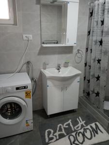 a bathroom with a washing machine and a sink at Stari Hrast 2 in Prolomska Banja
