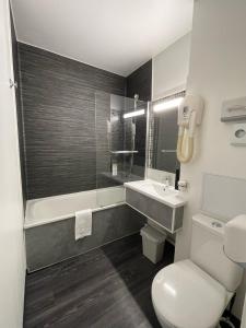 a bathroom with a toilet and a sink and a shower at Kyriad Saint Fargeau Ponthierry - Apollonia in Saint-Fargeau-Ponthierry