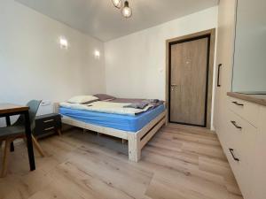 1 dormitorio con cama, mesa y puerta en Modern guest house in city center I Room 2 en Vilna