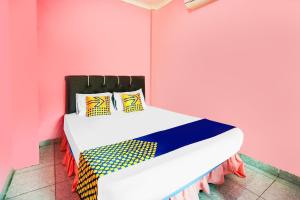 Camera rosa con letto e cuscini colorati di OYO Life 92046 Garuda Residence a Palembang