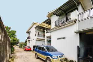 un furgone blu e giallo parcheggiato di fronte a un edificio di OYO Life 92046 Garuda Residence a Palembang