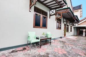 a patio with a table and chairs on a building at SPOT ON 92068 Pudja Kesuma Homestay Syariah Yogyakarta in Yogyakarta