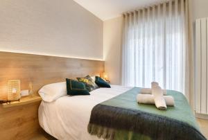 een slaapkamer met een groot bed en handdoeken bij Apartamentos La muralla de Jaca in Jaca