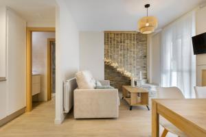 ein Wohnzimmer mit einem Stuhl und einem Tisch in der Unterkunft Apartamentos La muralla de Jaca in Jaca