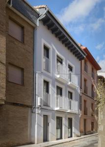 un edificio de apartamentos con balcones y una pared de ladrillo en Apartamentos La muralla de Jaca, en Jaca