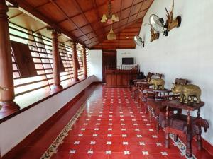 ein Zimmer mit Tischen und Stühlen in einem Gebäude in der Unterkunft Kalappura Farm House Heritage in Ottappālam