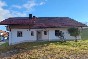 a small white house with a red roof at Gasthaus Schaupp in Kollnburg