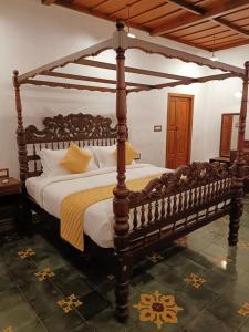 a large wooden canopy bed in a bedroom at Kalappura Farm House Heritage in Ottappālam