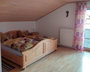 a bedroom with a large wooden bed in a room at Gasthaus Schaupp in Kollnburg