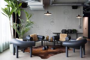 ein Wohnzimmer mit Stühlen und einem Tisch in der Unterkunft Basecamp Hotel Dortmund in Dortmund