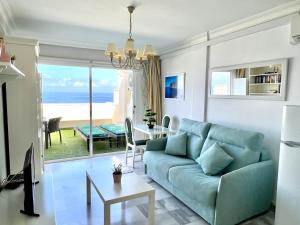 a living room with a blue couch and a table at Buenavista Top Floor Penthouse in Santiago del Teide