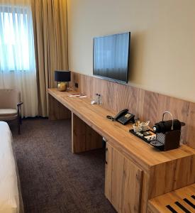 een hotelkamer met een bureau en een televisie aan de muur bij Hotel Le 830 Namur in Namen