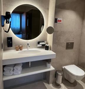 a bathroom with a sink and a mirror and a toilet at Hotel Le 830 Namur in Namur