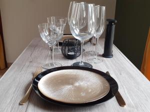 una mesa con un plato y copas de vino. en Gîte privé avec sauna et balnéo en Brens