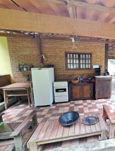 a kitchen with a white refrigerator and a stove at Chalé Hakuna Matata in Lumiar