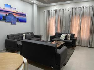 a living room with two couches and a table at Queens View Apartment in Accra