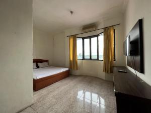 um quarto com uma cama e uma televisão em OYO 92098 Kost Orange Syariah em Gusung