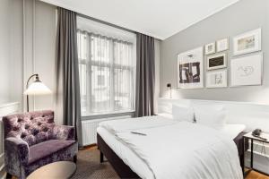 a hotel room with a bed and a chair at Hotel Kong Arthur in Copenhagen