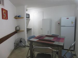 cocina con mesa, sillas y nevera en Oteiza Alojamiento Temporario en Resistencia a 150 mts peatonal en Resistencia