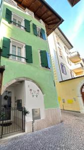 阿爾科的住宿－La Casa di Giò，绿色的白色建筑,上面有绿色的百叶窗