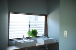 a bathroom with two sinks and a window at AMIGO HOUSE in Zushi