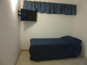 Habitación con cama azul y ventana en Oteiza Alojamiento Temporario en Resistencia a 150 mts peatonal en Resistencia