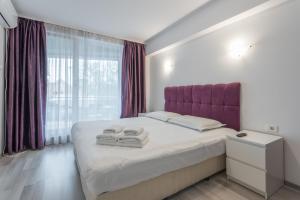 a bedroom with a bed with towels on it at CityScape Bucharest in Bucharest