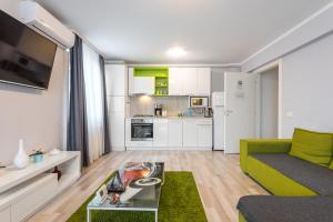ein Wohnzimmer mit einem Sofa und einem Tisch in der Unterkunft CityScape Bucharest in Bukarest