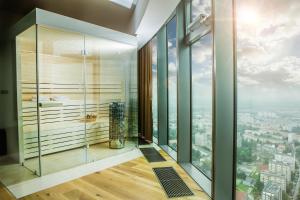 a bathroom with a glass shower with a view of a city at Apartamenty Sky Tower in Wrocław