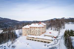 een groot gebouw in de sneeuw met sneeuw op de grond bij Apartamenty Kamienna z widokiem na góry i 2 km do Wyciągu Skolnity - Dream Apart in Wisła