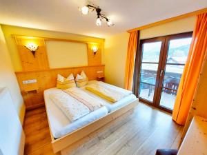 a bedroom with a bed and a large window at Landhaus Emanuel in Füssen