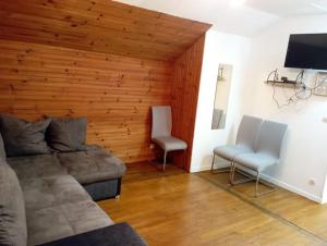 een woonkamer met een bank en 2 stoelen bij 3 pièces calme, terrasse et parking privé in Courcouronnes
