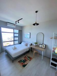 亞庇的住宿－Jesselton Quay by Bunga Raya Homes，卧室配有白色的床和桌子