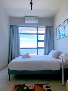 a bedroom with a bed with a large window at Jesselton Quay by Bunga Raya Homes in Kota Kinabalu