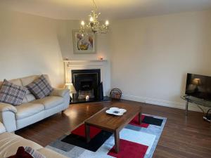 a living room with a couch and a coffee table at Modern 5 bedroom house in Spanish Point Clare in Spanish Point