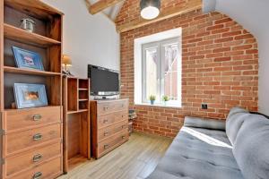 salon z kanapą i ścianą z cegły w obiekcie Hello Apartments Sw Ducha Loft for 4 guests w Gdańsku