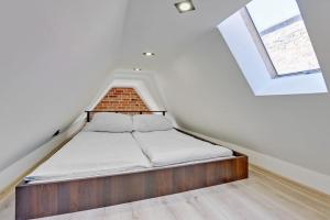 łóżko w pokoju z ceglaną ścianą w obiekcie Hello Apartments Sw Ducha Loft for 4 guests w Gdańsku
