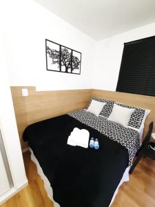 1 dormitorio con 1 cama con almohadas blancas y negras en Studio próximo Avenida Paulista - Bela 02, en São Paulo