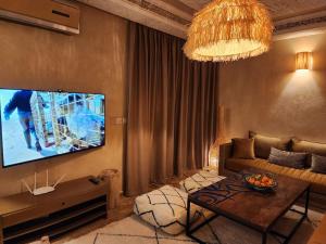 Un televizor și/sau centru de divertisment la Riad M. Jacuzzi - Piscine Arty/Cosy - Privatif