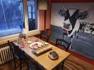 a dining room table with a cow painted on the wall at Gasthaus Schwand in Engelberg