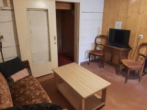 a living room with a couch and a table and a television at Gasthaus Schwand in Engelberg