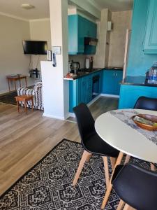 Una cocina con gabinetes azules y una mesa y sillas. en 4 Main Sail Port St Francis, en St Francis Bay