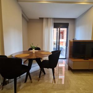 comedor con mesa, sillas y TV en BİSUİTES en Antalya