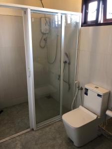 a bathroom with a shower and a toilet at SOHA Residency in Gampaha