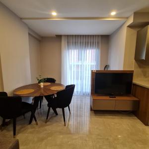 uma sala de estar com uma mesa e uma televisão em BİSUİTES em Antalya