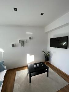 sala de estar con mesa de centro y TV de pantalla plana en Appartment Hoamatgfüh en Wagrain