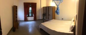 1 dormitorio con cama blanca y ventana en SOHA Residency, en Gampaha